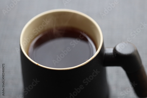 Obraz na płótnie A warm cup of coffee with steam rising from the surface, ready for a cozy morning. w salonie
