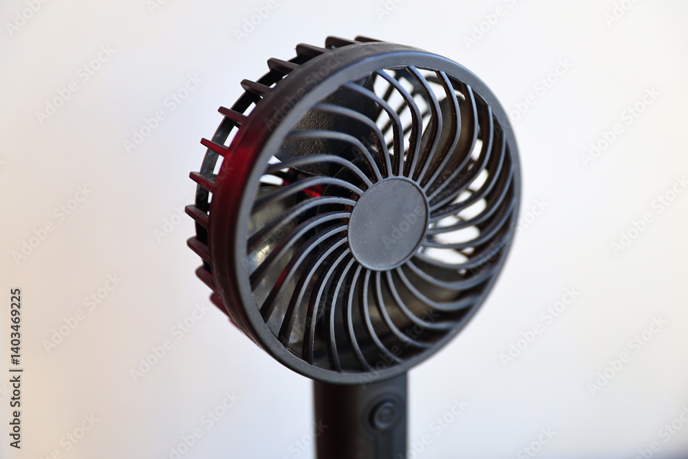 A small fan sits on top of a table, ready to circulate the air.