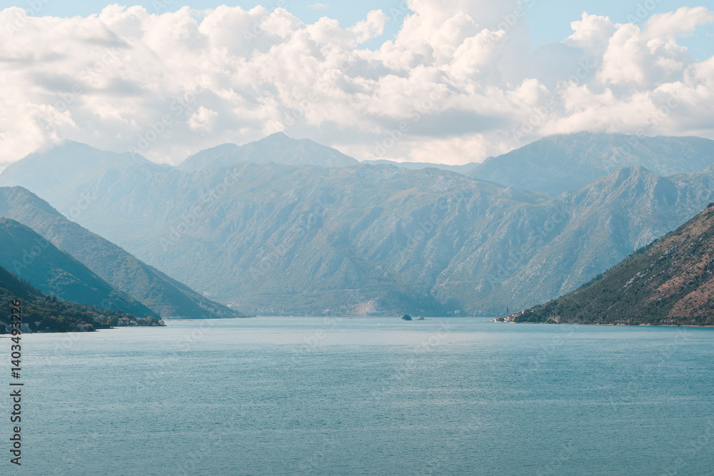 Majestic mountains by peaceful lake under clouds