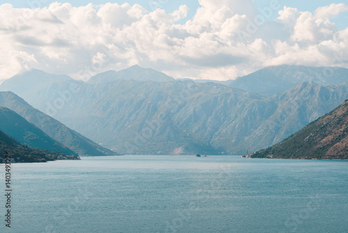 Majestic mountains by peaceful lake under clouds