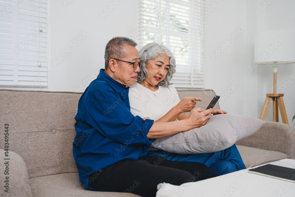 Obraz premium Senior couple enjoying pensionretirement while using smartphone together on cozy sofa in bright living room