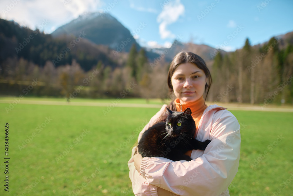 Woman trekking with black cat enjoying nature
