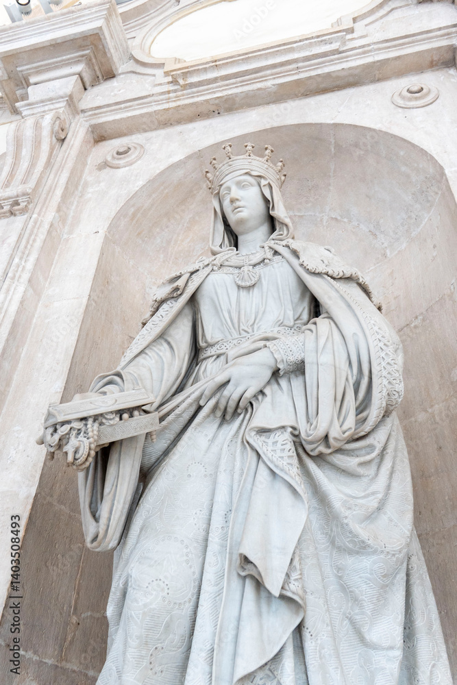 Fototapeta premium A woman in a white dress statue stands in front of a building