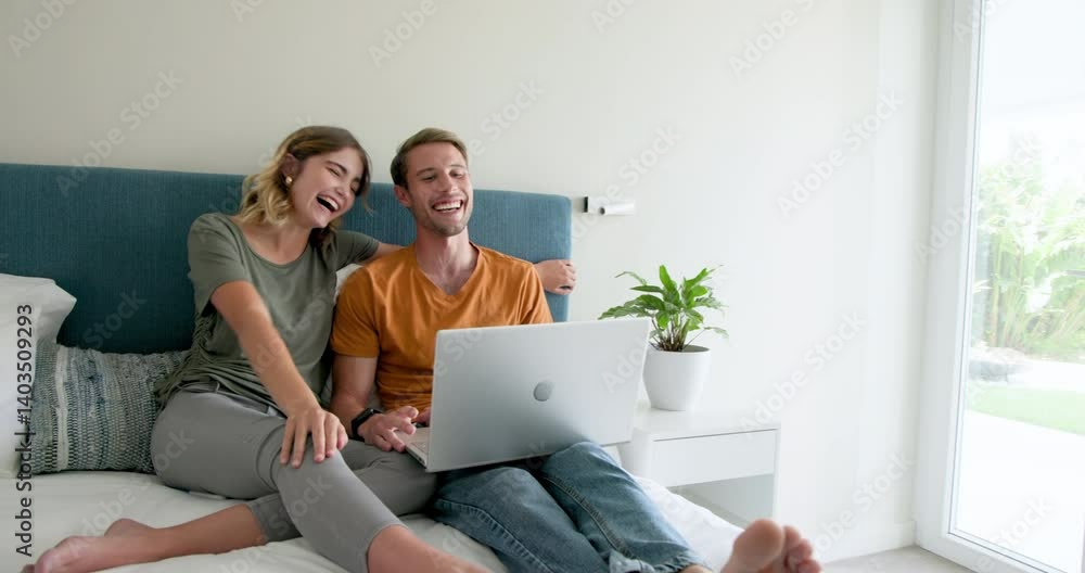 Video chatting, Couple relaxing on bed with laptop, enjoying quality time at home Video chatting, Couple relaxing on bed with laptop, enjoying quality time at home