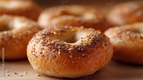 Group of freshly baked bagels on a wooden surface. the bagels are golden brown in color and have sesame seeds sprinkled on top.