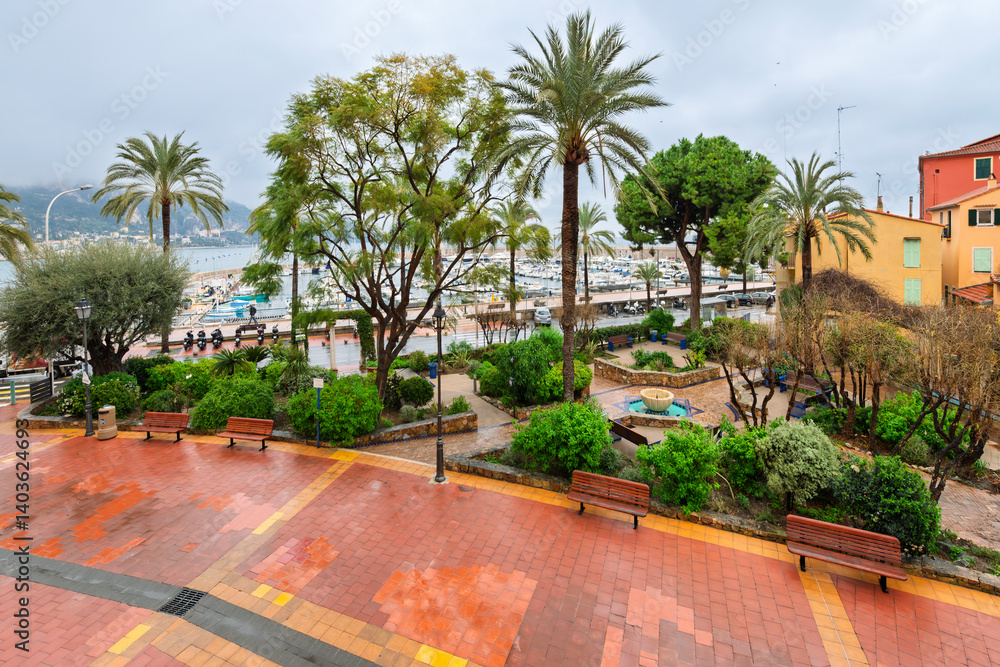 Fototapeta premium The Jardin du Campanin Park in the seaside town of Menton France, with the Mediterranean Sea, marina and beach in view on a rainy day on the French Riviera.