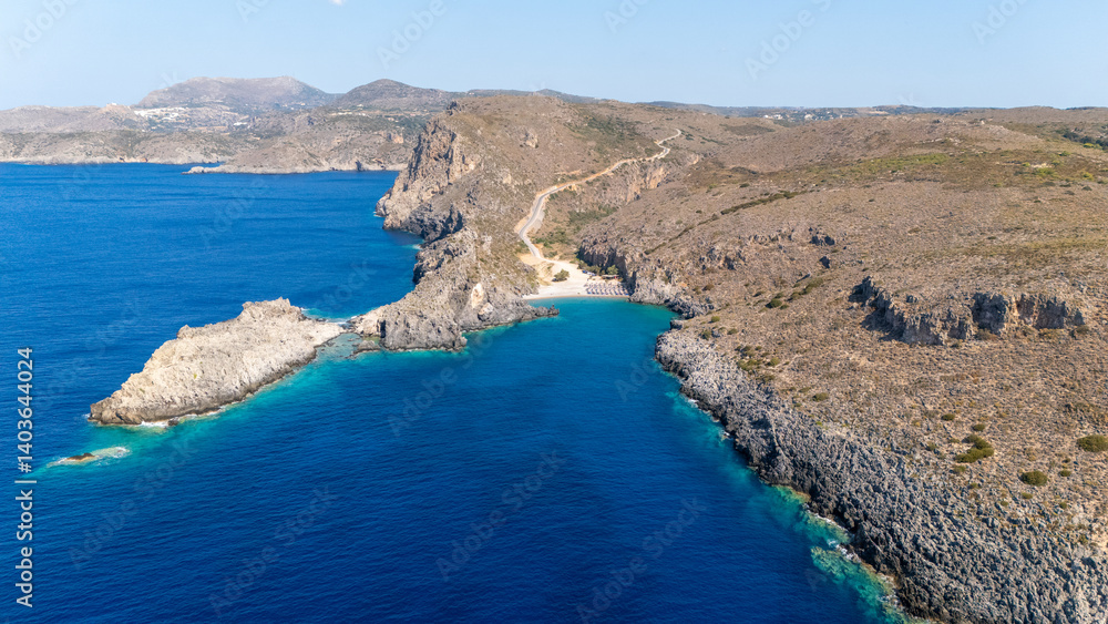 Obraz premium Chalkos beach in Kythira - Scenic beach with sun umbrellas and clear waters nestled between rocky cliffs on a sunny day in a coastal region