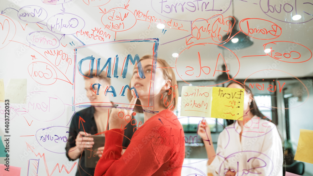 Creative business team brainstorming and sharing marketing idea about start up project by writing down on colorful sticky note at glass board modern meeting room. Working together. Immaculate.