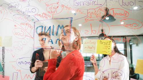 Creative business team brainstorming and sharing marketing idea about start up project by writing down on colorful sticky note at glass board modern meeting room. Working together. Immaculate.