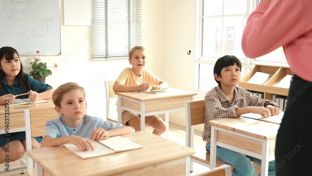 Back view of caucasian teacher teach diverse student while standing at blackboard. Professional instructor explain classwork while student looking and listen carefully. Education concept. Pedagogy.