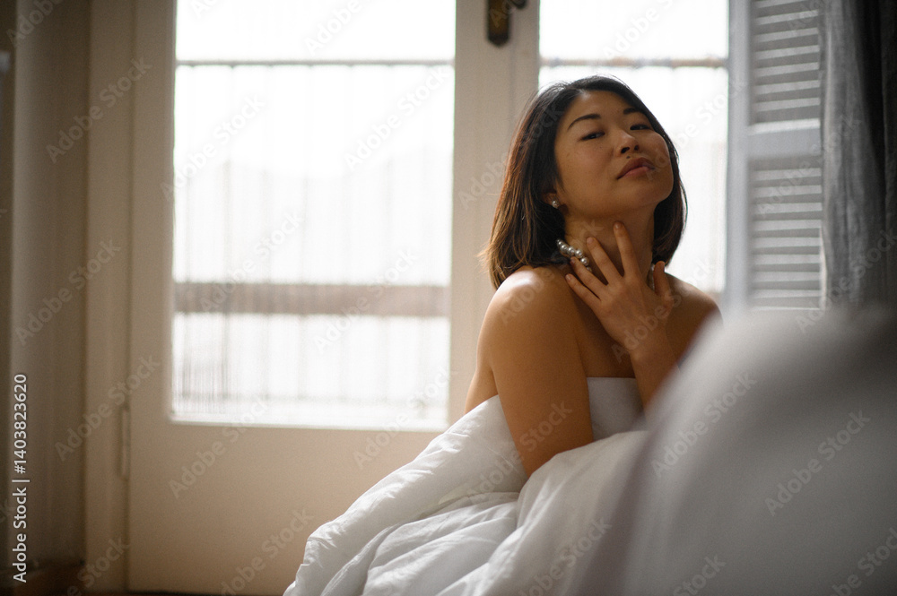 Elegant asian woman touching large white pearl necklace on her bare neck and shoulders. Minimalist close-up capturing feminine beauty, sensuality and luxury jewelry detail. Elegant asian woman touching large white pearl necklace on her bare neck and shoulders. Minimalist close-up capturing feminine beauty, sensuality and luxury jewelry detail.