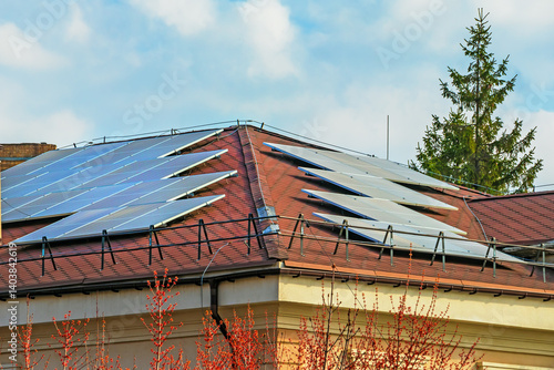 Solar panels on the hip roof of a modern building - an alternative source of electrical energy. PV modules are a device that converts sunlight into electricity
