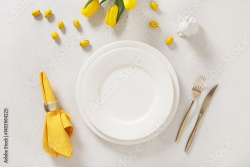 Obraz na płótnie Easter table setting with spring, yellow tulips, white plates, bunny, eggs on white background. Happy Easter celebration. Copy space. View from above. w salonie