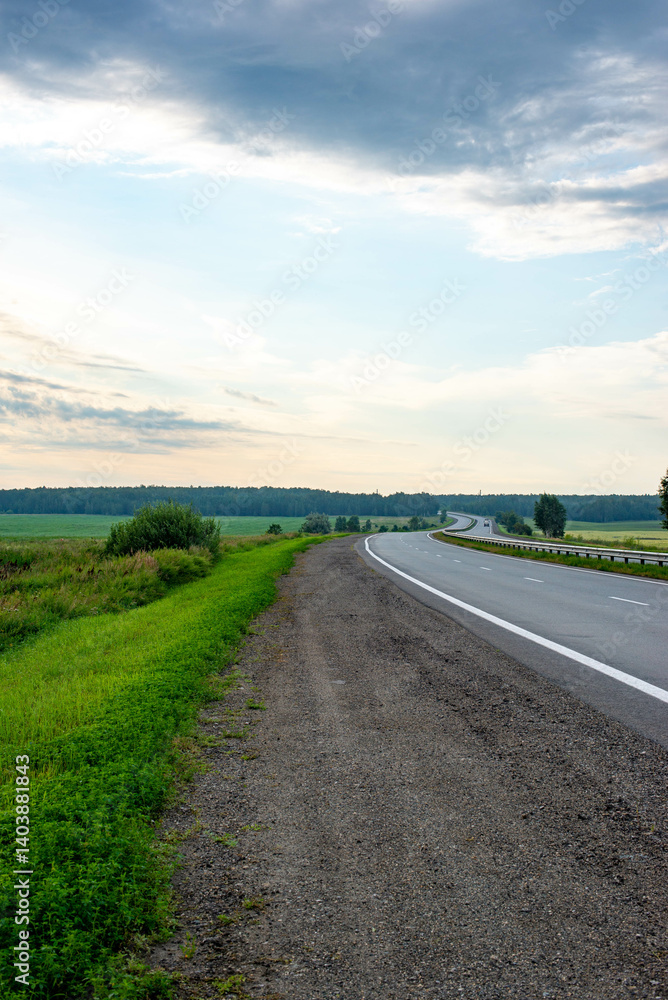 The highway is early in the morning and the fields are green The highway is early in the morning and the fields are green