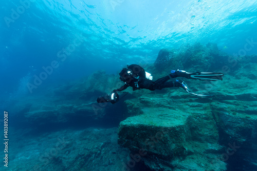 Sub con bibombola e dpv, sullo sfondo rocce vulcaniche, isola di Tenerife