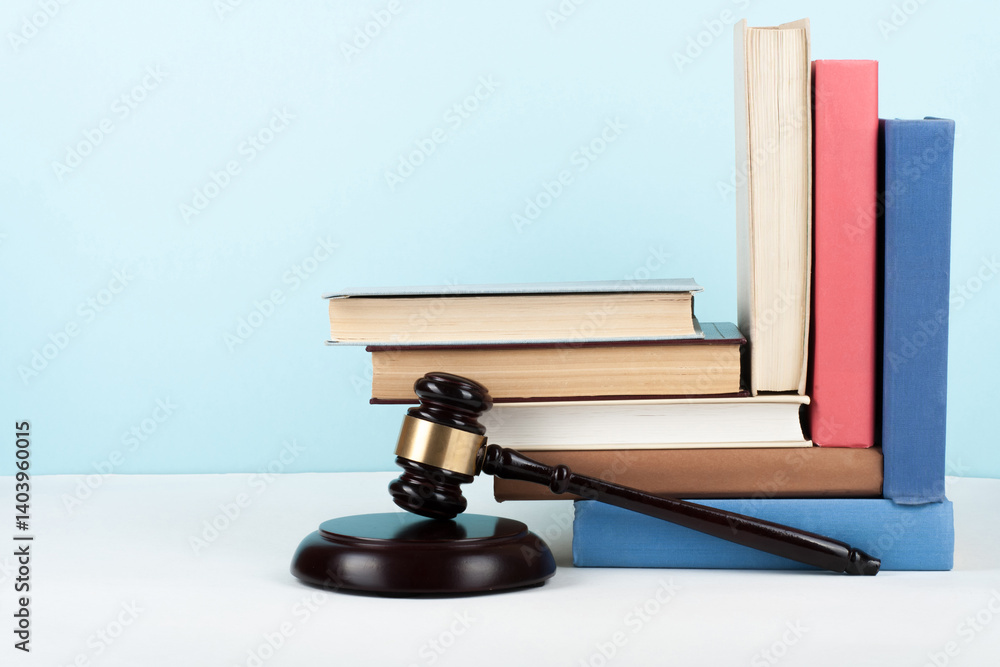 Law concept open book with wooden judges gavel on table in a courtroom or law enforcement office, blue background. Copy space for text. Law concept open book with wooden judges gavel on table in a courtroom or law enforcement office, blue background. Copy space for text.