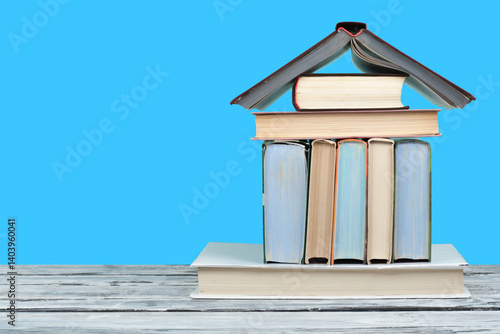 Open book, hardback colorful books on wooden table and blue background. Back to school. Copy space for text. Education business concept.