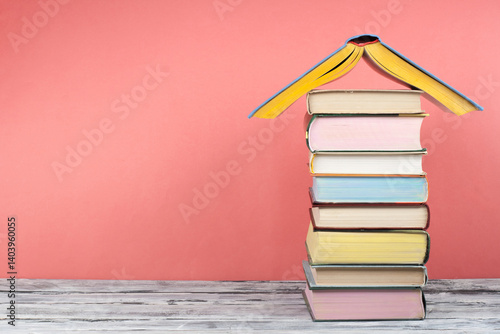Open book, hardback colorful books on wooden table, red background. Back to school. Copy space for text. Education business concept.