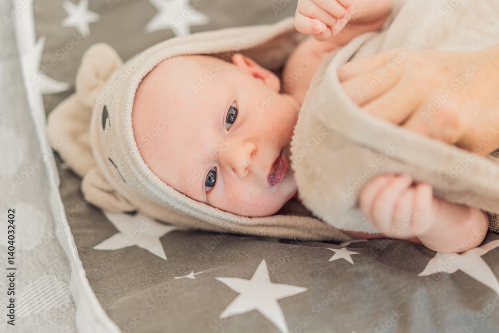 A newborn baby lies wrapped in a soft towel after a warm bath, enjoying a moment of comfort and relaxation. A heartwarming scene symbolizing baby care, hygiene, and the soothing bond of early