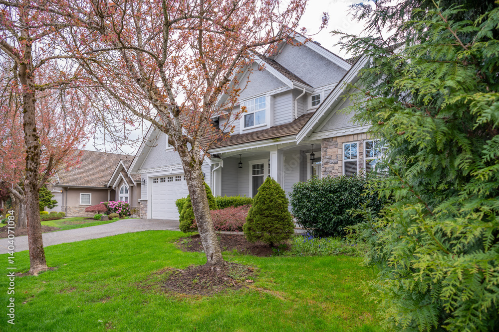 Two story stucco luxury house with nice spring blossom landscape in Vancouver, Canada, North America. Day time on April 2025. Two story stucco luxury house with nice spring blossom landscape in Vancouver, Canada, North America. Day time on April 2025.