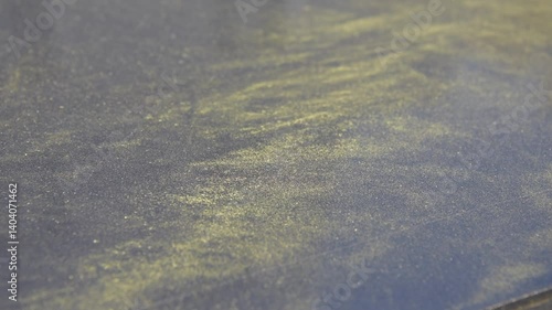 Yellow birch pollen lies on a metal surface. Close-up.