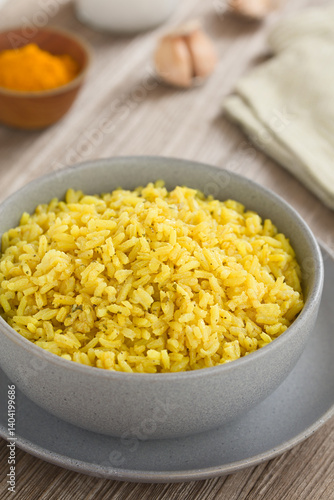 Homemade cooked yellow rice side dish, cooked with turmeric, onion, garlic, salt, pepper and coriander, served in bowl (Selective Focus, Focus in the middle of the rice)