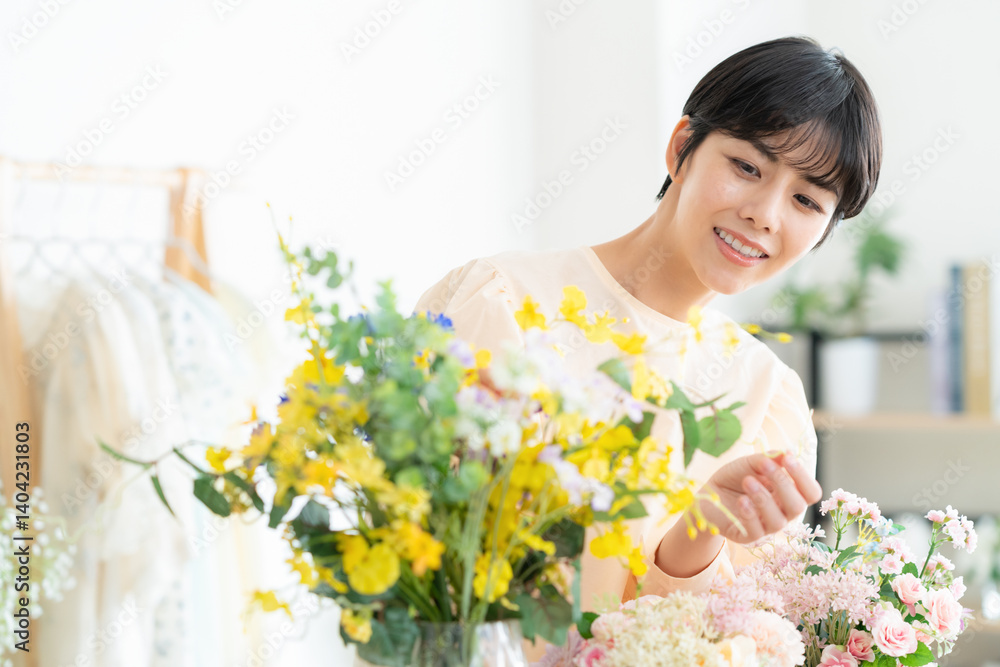 リビングでフラワーアレンジメントをする若い女性