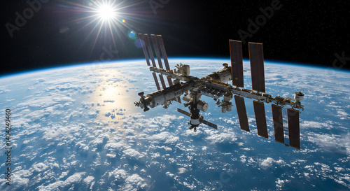 Fototapeta Naklejka Na Ścianę i Meble -  International Space Station Orbiting Earth With Sunlight and Cloudscape Against Starry Black Sky in High Detail