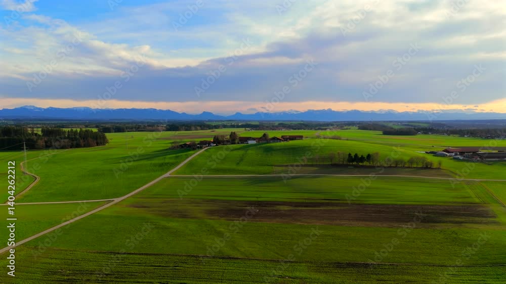 Aerial view of green fields in spring, Bavaria, Germany, showcasing sown crops, lush vegetation and rural farmland. Symmetrical rows stretch to horizon with distant mountains enhancing scenic beauty. Aerial view of green fields in spring, Bavaria, Germany, showcasing sown crops, lush vegetation and rural farmland. Symmetrical rows stretch to horizon with distant mountains enhancing scenic beauty.