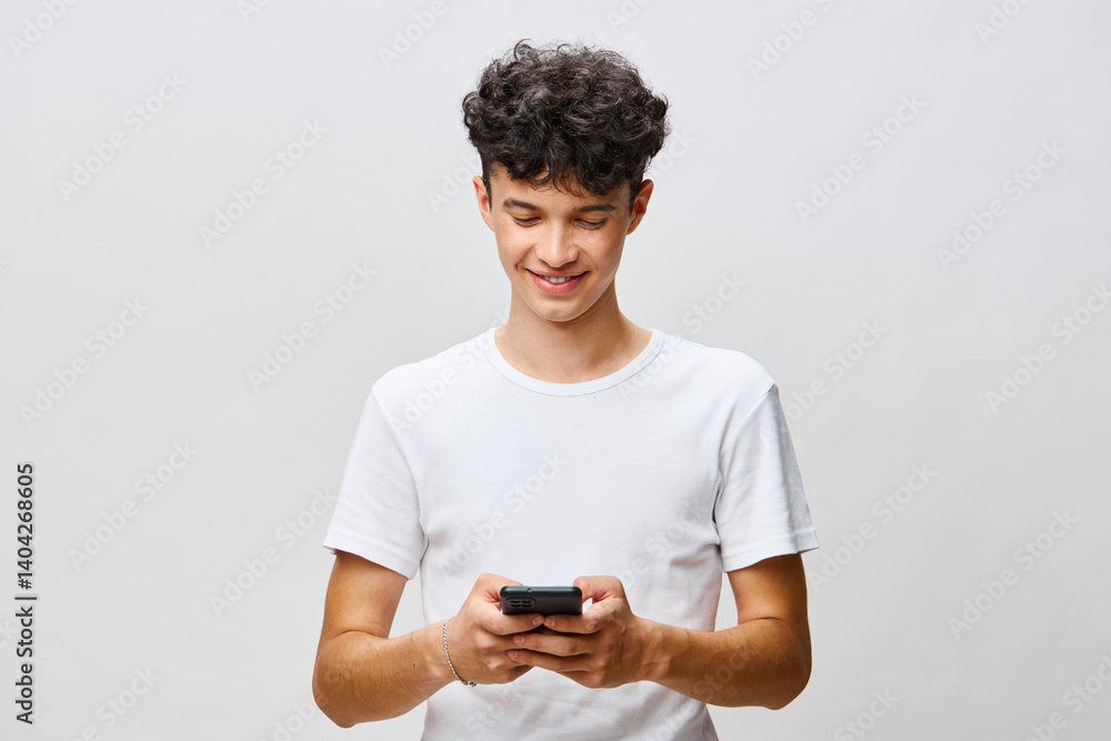 smiling young man using smartphone, casual attire, light background, modern communication, technology, social media, youth culture, connection, everyday life, engagement with devices smiling young man using smartphone, casual attire, light background, modern communication, technology, social media, youth culture, connection, everyday life, engagement with devices