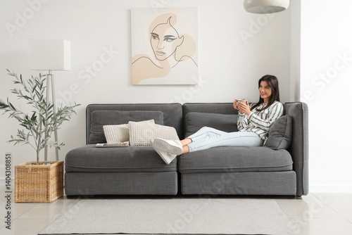 Young woman with cup restin...
