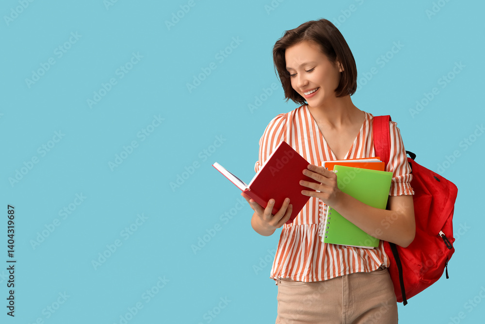 Beautiful female student with backpack and notebooks on blue background Beautiful female student with backpack and notebooks on blue background