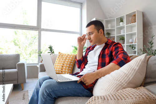 Young man using laptop on g...