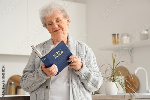 Senior woman reading Bible ...