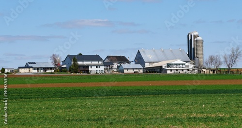 Canvas Print Farmhouse with silos stand tall against a backdrop of meticulously cultivated fields near Lancaster County, Pennsylvania, U