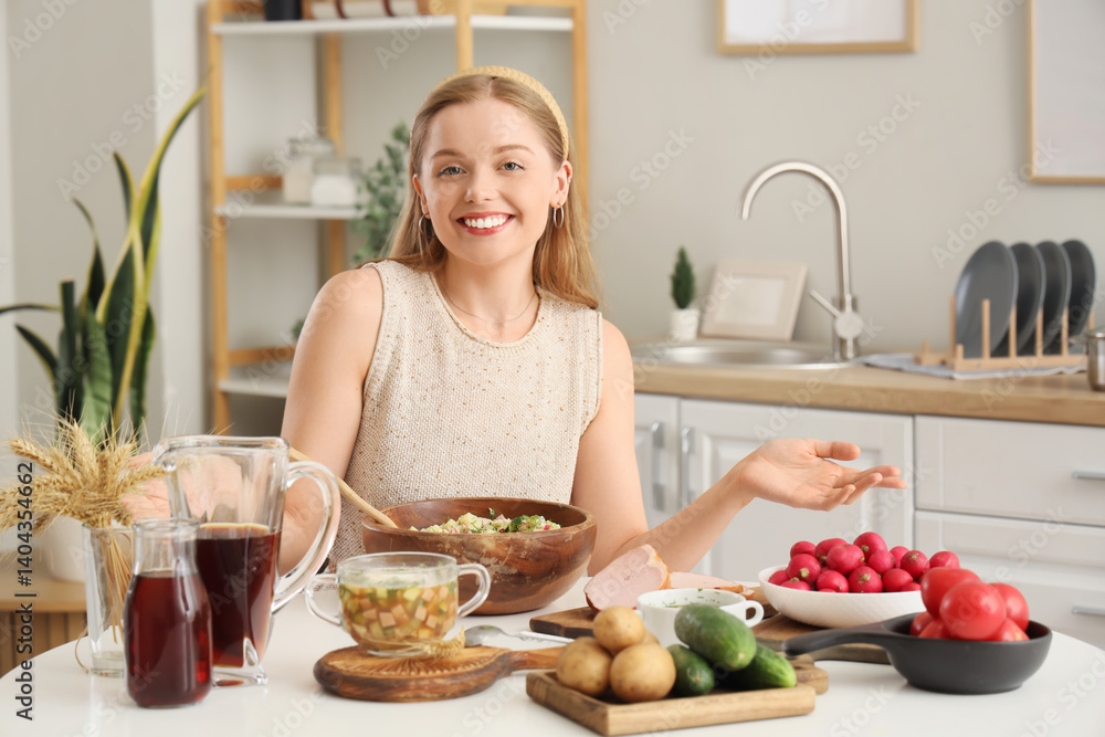 Young woman cooking okroshka at table in kitchen Young woman cooking okroshka at table in kitchen