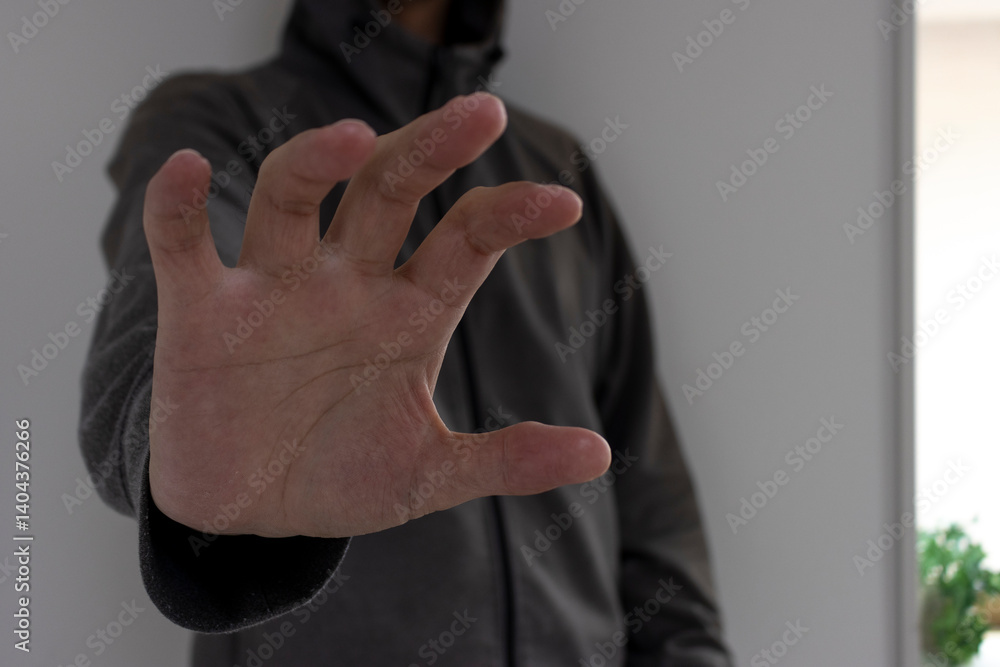 暗い部屋で何かを掴もうと手を伸ばす怪しい男