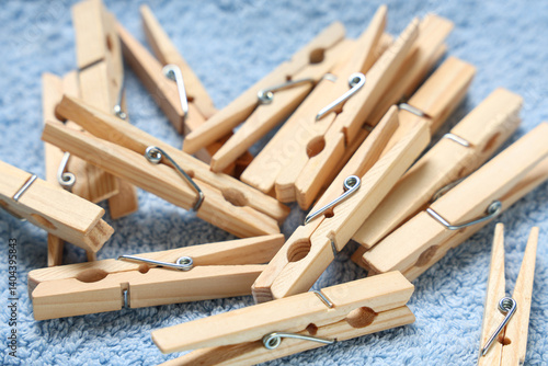 Wooden clothespins on clean towel as background, closeup