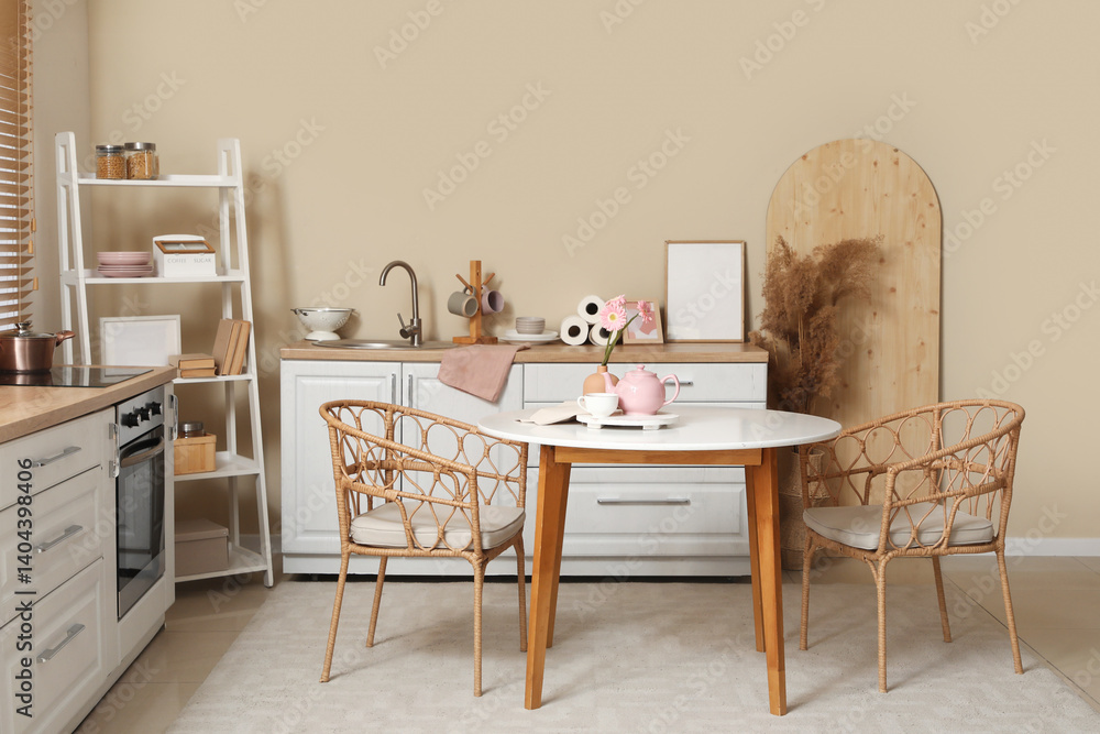 Fototapeta premium Interior of kitchen with pink teapot, cup of tea and beautiful flowers on table
