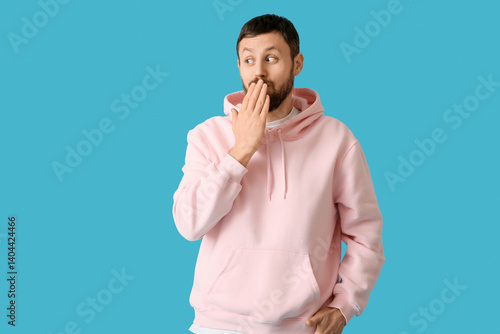 Surprised young man on blue...