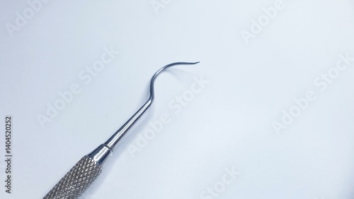 Close-up of a dental scaler tool on a white background. Ideal for medical, dental, or healthcare related projects.
