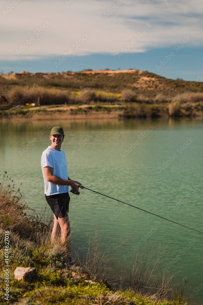Young Man Fishing by a Peaceful Green Lake Young Man Fishing by a Peaceful Green Lake