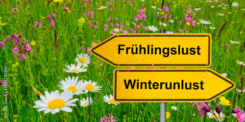 Obraz na płótnie Ein Wegweiser zeigt in unterschiedliche Richtungen mit der Aufschrift Frühlingslust und Winterunlust - FOTOMONTAGE w salonie