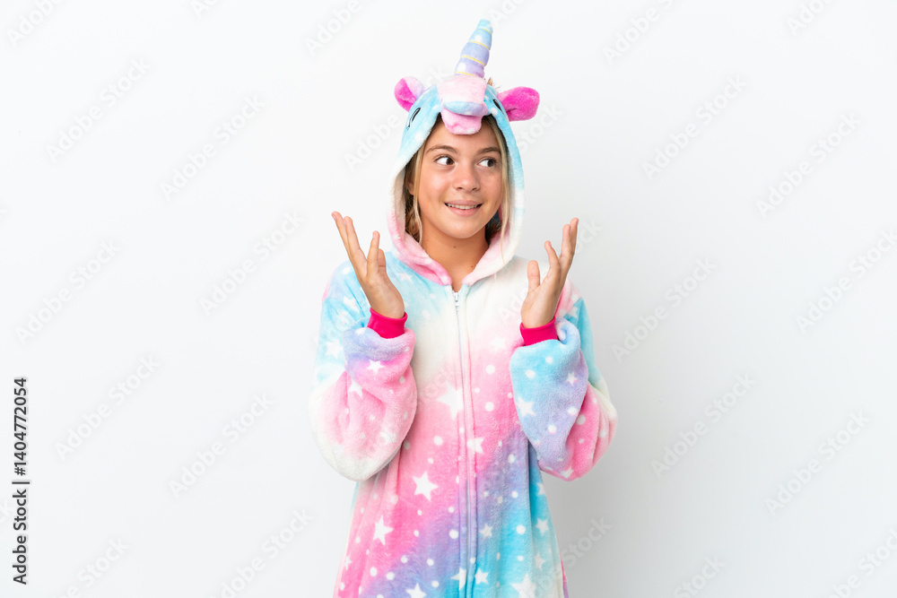 Little girl with unicorn pajamas isolated on white background with surprise facial expression Little girl with unicorn pajamas isolated on white background with surprise facial expression