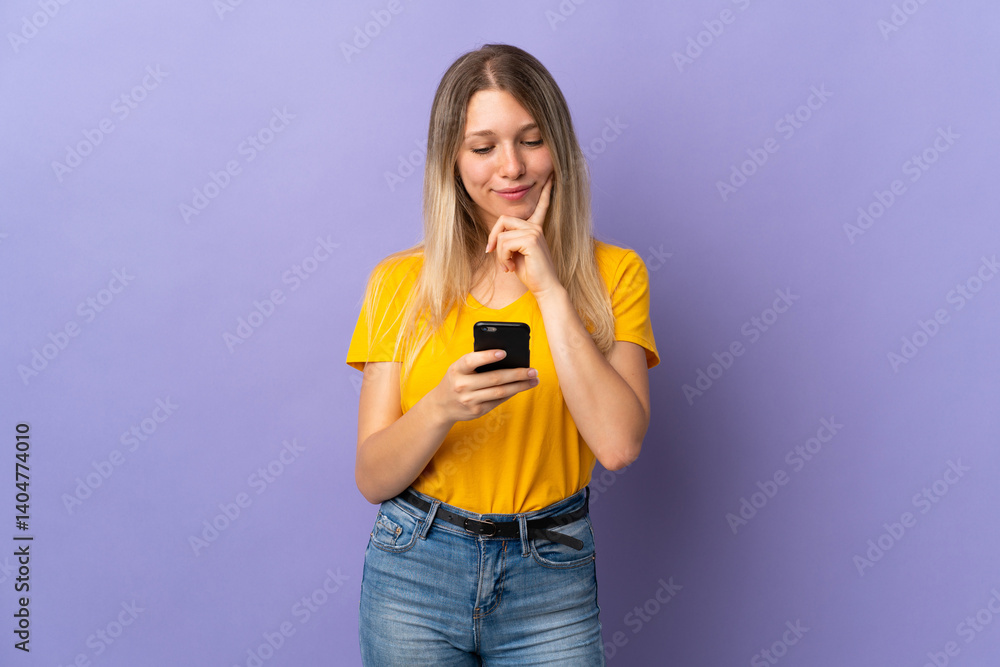 Young blonde woman isolated on purple background thinking and sending a message Young blonde woman isolated on purple background thinking and sending a message