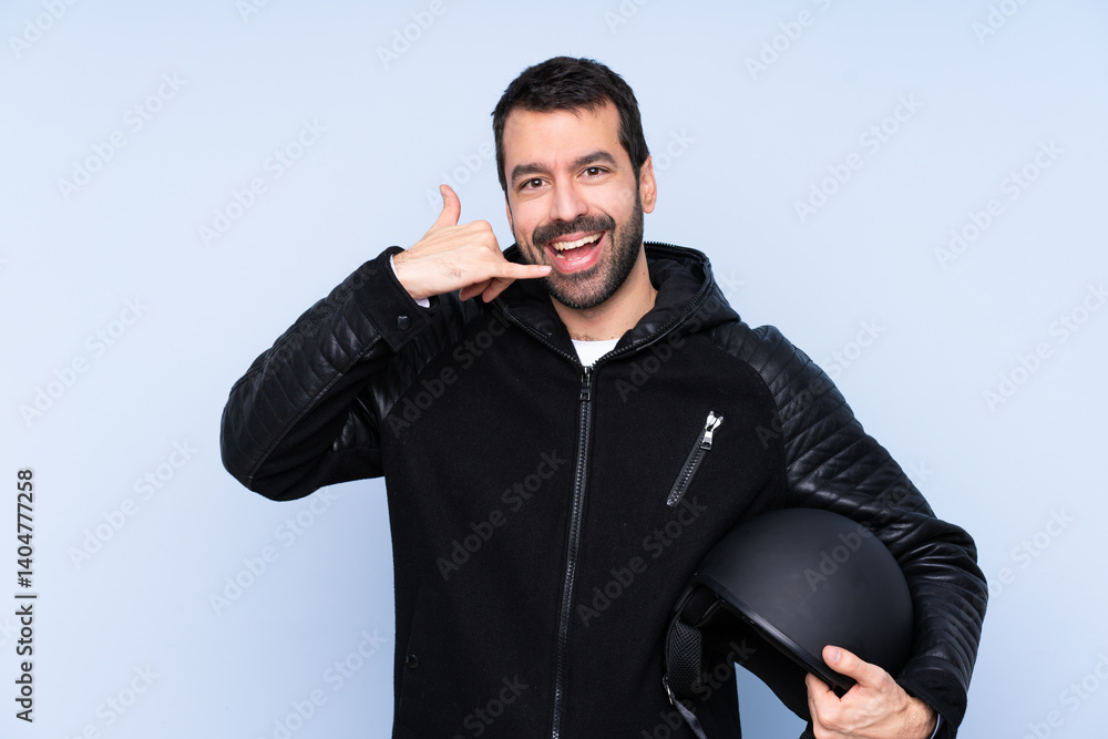 Man with a motorcycle helmet over isolated background making phone gesture. Call me back sign Man with a motorcycle helmet over isolated background making phone gesture. Call me back sign