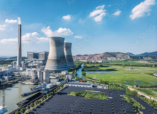 Photography Aerial view of thermal power plant with cooling towers chimneys and solar panels near river and green fields background