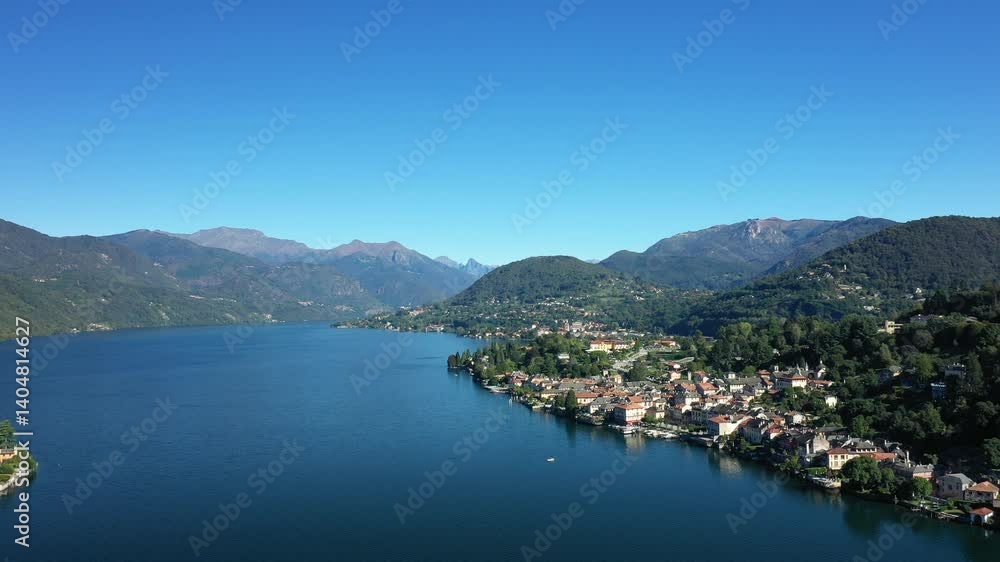 The town of Orta facing the island of Isola San Giulio in Europe, Italy, Piedmont, in summer, on a sunny day. The town of Orta facing the island of Isola San Giulio in Europe, Italy, Piedmont, in summer, on a sunny day.