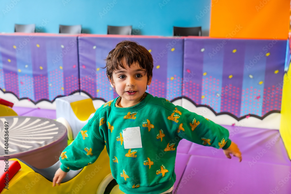 Happy child playing in colorful indoor playground area