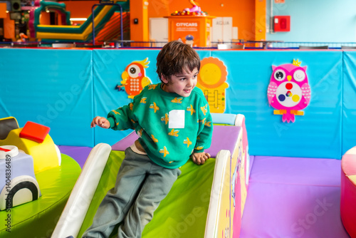 Obraz na płótnie Happy child sliding down in soft play area at indoor playground w salonie